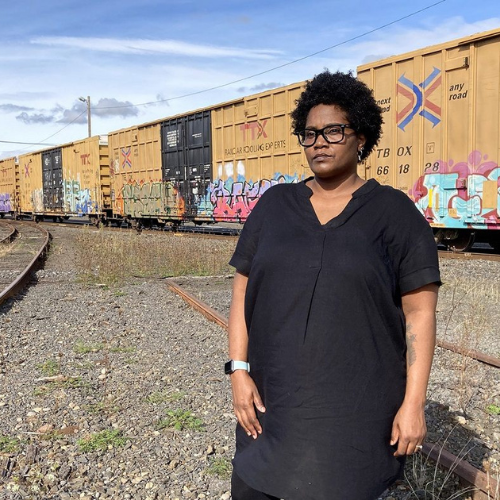 Host Arjorie Arberry-Baribeault standing near a train.
