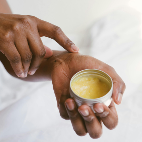 A woman applying a cream to her hands.