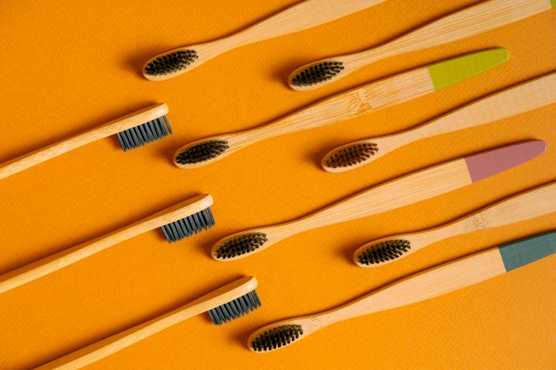 Wooden toothbrushes on an orange background.
